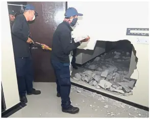  ??  ?? Illegal partition: Penang Island City Council enforcemen­t officers knocking down a room at an unlicensed hotel in George Town during a recent operation.