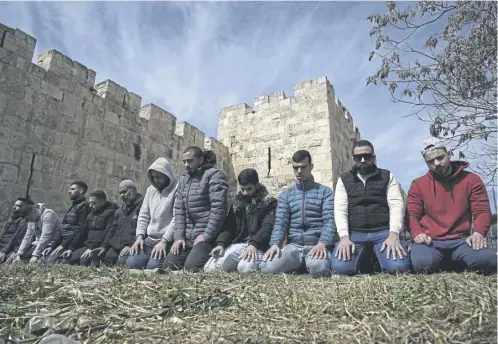  ?? ?? Palestinia­n Muslims pray outside of the walls of the Old City of Jerusalem after Israeli police denied their entry to the Al-aqsa Mosque compound for Friday prayers as protests continue over shootings of people attempting to get food aid in Gaza that left more than 100 dead