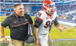  ??  ?? Blankenshi­p runs to the postgame interviews for the 2016 Kentucky game donning his helmet and now trademark glasses.