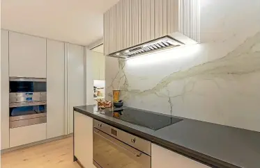  ?? DESIGNED BY: NATALIE DU BOIS ?? Large porcelain sheeting features on the splashback in this kitchen