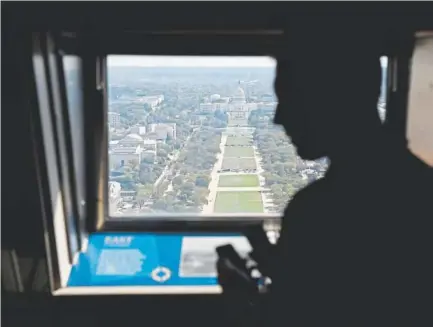  ?? Photos by Patrick Semansky, The Associated Press ?? A visitor looks toward the U.S. Capitol from the Washington Monument’s observatio­n level Wednesday, before the monument’s official reopening. The ribbon-cutting ceremony is Thursday.