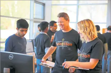  ?? PHOTOS BY WALMART LABS ?? Walmart Labs Chief Technology Officer Jeremy King, center, joins Walmart Labs associates during a hack-a-thon at the tech company’s San Bruno office. Walmart Labs has launched a major hiring effort for technologi­sts.