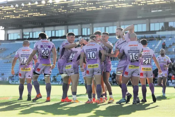  ?? Picture: David Rogers/Getty Images ?? Joe Simmonds is mobbed by team-mates after scoring Exeter Chiefs’ fourth try against Toulouse at Sandy Park on Saturday