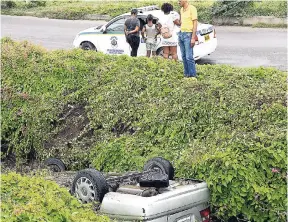  ?? NORMAN GRINDLEY/CHIEF PHOTO EDITOR ?? The driver of this Nissan motor car was rushed to hospital after losing control of the vehicle and overturnin­g into this gully on Weymouth Drive in St Andrew, yesterday.