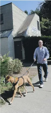  ?? RIC ERNST/PNG FILES ?? Volunteer Chris Ness walks a dog named Dakota outside the B.C. SPCA. The SPCA seized a different dog, Koba, after owner Chad Hubick admitted to throwing the canine across a room in a fit of anger.