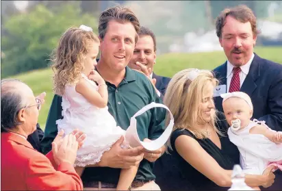  ?? COURANT FILE PHOTO ?? Phil Mickelson and his family enjoy the ceremonies on the 18th green after he won the GHO with a birdie on the final hole in 2002. His wife, Amy, is holding 7-month-old Sophia. Phil is holding 3-year-old Amanda.
