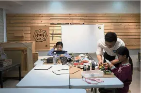  ??  ?? Young ‘makers’: A teacher instructin­g children at ‘MG Space’, a workshop offering digital fabricatio­n, in Shenzhen. — AFP