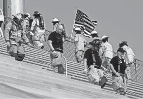  ??  ?? Firefighters takethe stadium steps at Fortress Obetz. Local firefighters were among those who climbed the equivalent of the 110 stories of the World Trade Center. The US flag with the red stripe symbolizes “the thin red line” and honors firefighters who have been injured and killed in the line of duty.