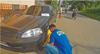  ?? AMPER CAMPAÑA SUNSTAR FOTO / ?? CLAMPED. A traffic enforcer clamps a vehicle for alleged illegal parking on Villalon Drive, Capitol Site, Cebu City .