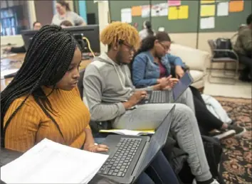  ??  ?? Woodland Hills students Debrieanna Eddins, 17, left, Montrell Horton, 18 and Keara Bowden, 18, work on their resumes.