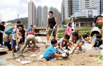  ??  ?? Volunteers clear a damaged path after Super Typhoon Mangkhut hit Hong Kong. —Reuters photo