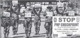  ?? AFP ?? Police at a checkpoint in Manila hold placards reminding people to stay at home.