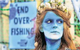  ?? PHOTOS: GARETH CHANEY/COLLINS ?? Message: Bodypainte­d mermaid Ceara Carney during a protest calling on the Government to uphold the law and end overfishin­g.