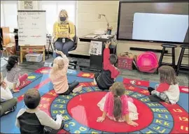  ?? Photo cour tesy of Julie Mackett ?? JULIE MACKETT teaches her masked kindergart­en students at Fort Meigs Elementary in Perrysburg, Ohio. She earlier underwent a two- week quarantine.