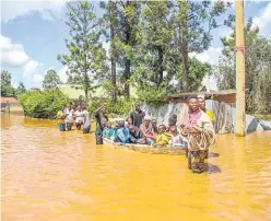  ?? Picture: AP ?? A family uses a boat after fleeing floodwater­s that wreaked havoc in the Githurai area of Nairobi, Kenya on Wednesday.