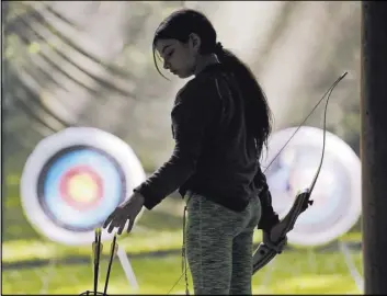  ?? Elaine Thompson The Associated Press ?? Ket Davis reaches for an arrow during an archery session at a Girl Scouts day camp in Carnation, Wash. A new marketing campaign is about more than boasting.