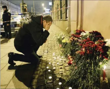  ?? OLGA MALTSEVA/AFP ?? A man reacts as he places flowers in memory of victims of the blast in the Saint Petersburg metro outside Technologi­cal Institute station on Tuesday.