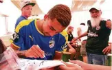  ??  ?? Fußballer zum Anfassen: Justin Schau schreibt Autogramme im Festzelt.