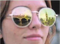  ?? FOTO: AFP ?? Big Ben spiegelt sich in der Sonnebrill­e einer Frau: Das Geläut des Touristenm­agneten der britischen Hauptstadt kennt wohl jeder.