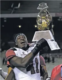  ??  ?? New Mexico State linebacker Terrill Hanks lifts the Arizona Bowl trophy after the Aggies defeated Utah State on Friday.