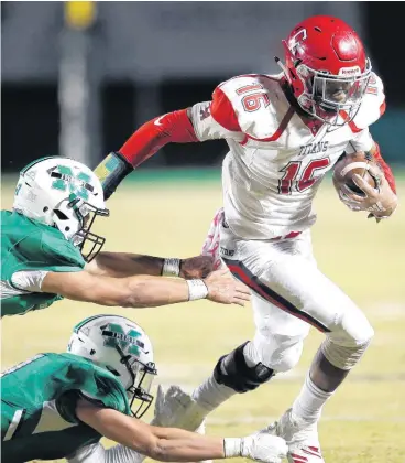  ?? [PHOTO BY SARAH PHIPPS, THE OKLAHOMAN] ?? Carl Albert’s Dadrion Taylor gets by McGuinness’s Luke Tarman, top, and Cooper Wright during Friday’s game in Oklahoma City.