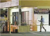  ??  ?? Police work to gather evidence outside Club Blu. Three people were being held for questionin­g in the incident.
