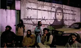  ?? Afghanista­n. Photograph: Felipe Dana/AP ?? Taliban members in front of a mural depicting a woman behind barbed wire in Kabul,