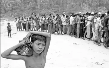  ??  ?? Rohingya refugees line up to receive blankets outside Kutupalong refugee settlement near Cox’s Bazar, Bangladesh. — Reuters photo