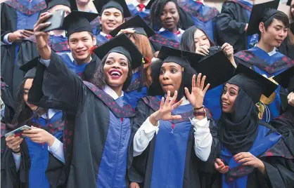  ??  ?? Emefa takes a graduation picture with her fellow classmates at Guangdong University of Foreign Studies.