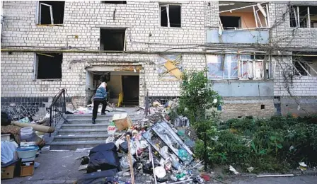  ?? NATACHA PISARENKO AP ?? A resident enters her apartment building that was heavily damaged by shelling in Borodyanka, Ukraine, on Tuesday.