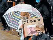  ?? MICHEL SPINGLER/AP ?? A child holds a poster of Samuel Paty during a tribute Sunday in Lille, France. Paty, 47, was beheaded Friday.