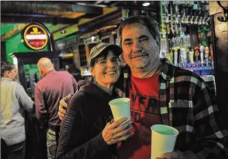  ?? MARSHALL GORBY / STAFF ?? Jeff and Lori Law celebrated the early closing Sunday at the Dublin Pub by buying a round of shots for everyone inside. Gov. Mike DeWine ordered all bars and restaurant­s be closed at 9 p.m. Sunday night.