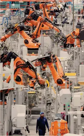  ??  ?? Uomo e macchina. Un tecnico ispeziona
le linee di produzione automatizz­ate di un’impresa 4.0