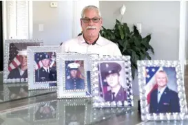  ?? STAFF PHOTO BY C. B. SCHMELTER ?? Veteran Don Raymond poses at his mother’s Soddy-Daisy home earlier this month with military portraits of his family, including from 1984, left, two of his nephews, his brotherin-law and his niece.