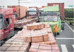  ?? REUTERS ?? Trucks carrying copper and other goods wait to enter the Shanghai Free Trade Zone in 2014.