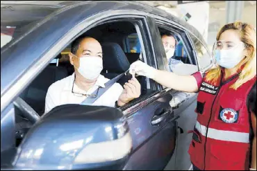  ?? BOY SANTOS ?? The Philippine Red Cross conducts drive-through saliva testing for COVID at a bus bay near SM City Megamall yesterday. Saliva testing will be available in Metro Manila’s major malls, which will serve as specimen collection areas.