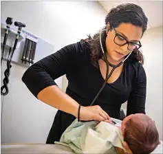  ?? Associated Press ?? Dr. Jasmine Saavedra, a pediatrici­an at Esperanza Health Centers whose parents emigrated from Mexico in the 1980s, examines Alondra Marquez, a newborn baby in her clinic in Chicago. Doctors and public health experts warn of poor health outcomes and rising costs they say will come from sweeping changes that would deny green cards to many immigrants who use Medicaid, as well as food stamps and other forms of public assistance. Saavedra is convinced that if new Trump administra­tion criteria were in effect for her parents three decades ago, she wouldn’t have become a pediatrici­an.