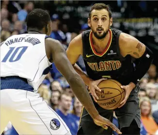  ?? LM OTERO / ASSOCIATED PRESS ?? Guard Marco Belinelli looks to pass against the Mavericks’ Dorian Finney-Smith during his 20-point performanc­e in the Hawks’ season-opening victory Wednesday night.