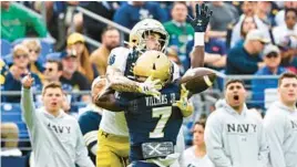  ?? TERRANCE WILLIAMS/AP ?? Notre Dame wide receiver Braden Lenzy catches the ball against Navy cornerback Mbiti Williams Jr. for a touchdown during the first half Saturday in Baltimore.