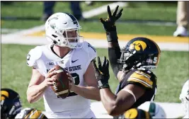  ?? CHARLIE NEIBERGALL — THE ASSOCIATED PRESS ?? Michigan State quarterbac­k Rocky Lombardi, left, is pressured by Iowa defensive lineman Chauncey Golston, right, during the first half of Saturday’s game.