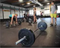  ?? Photo by Ernest A. Brown ?? General Manager David Cardenas, of Providence, a fitness coach at Industrial Revolution Crossfit in Pawtucket, oversees training routines at the gym.