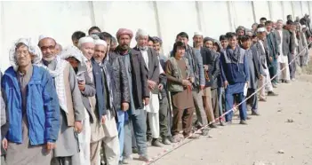  ?? — Reuters ?? Afghan men line up to cast their votes during the parliament­ary election at a polling station in Kabul.