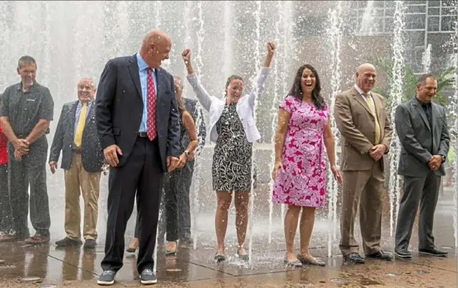  ??  ?? Don Belt’s red tie and dark suit get the opposite of a dry cleaning as he leads other business executives in the CEO Soak for ALS fundraiser Thursday at the PPG Place fountain.