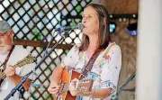  ??  ?? Monica Taylor performs “The Price of Love,” a song she and the late Jimmy LaFave recorded together, on July 12 during the Woody Guthrie Folk Festival in Okemah.