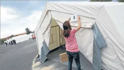  ??  ?? Una dona numera una de les tendes per acollir refugiats en un campament a Berlín