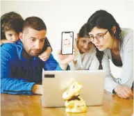  ?? ALESSANDRO GAROFALO / REUTERS ?? Family members talk to their relatives on a video call
Monday in Cisternino, southern Italy.