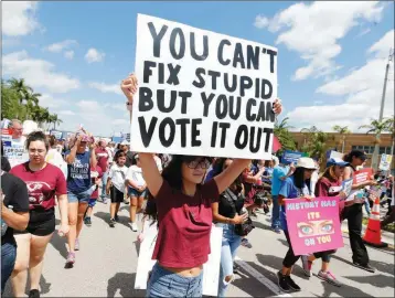  ?? ASSOCIATED PRESS ?? IN THIS MARCH 24 FILE PHOTO, people take part in a “March For Our Lives” rally March 24 in Parkland, Fla.