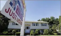  ?? ASSOCIATED PRESS ?? A for sale sign hangs in front of a house.