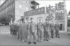  ??  ?? Members of the testing team pose for a photo in front of a temporary laboratory at the hospital in Dalian in July last year.