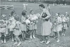  ?? ELLIS LITTLE LOCAL HISTORY ROOM, WATERLOO PUBLIC LIBRARY ?? Below right: Olivia Schmuck judges a doll competitio­n at the Sunshine Waterloo Company picnic in the park in 1945. The children are daughters of the company's employees, and Schmuck became the matron nurse at the company in 1944. She died in 1986.Below: A group of Record newspaper carriers at the carriers' picnic held at Waterloo Park, Aug. 6, 1923.